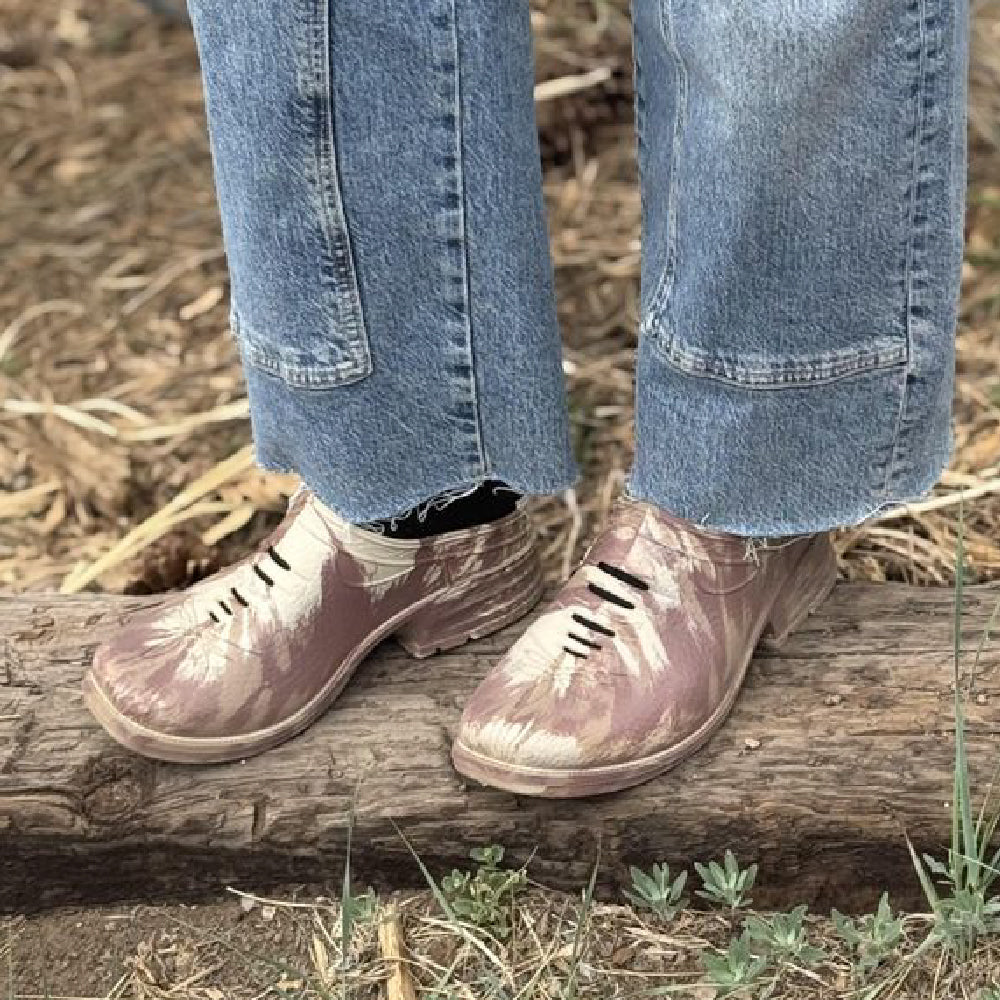 Person wearing Westech Outrider slip-on shoes in Sierra Ferrell marble pattern standing on a log in nature, showing the versatile Western comfort footwear in real outdoor use, Made in USA